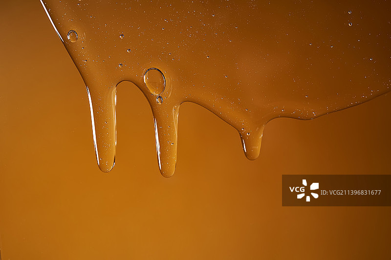 滴落在黄色背景上的沐浴露或洗发水图片素材