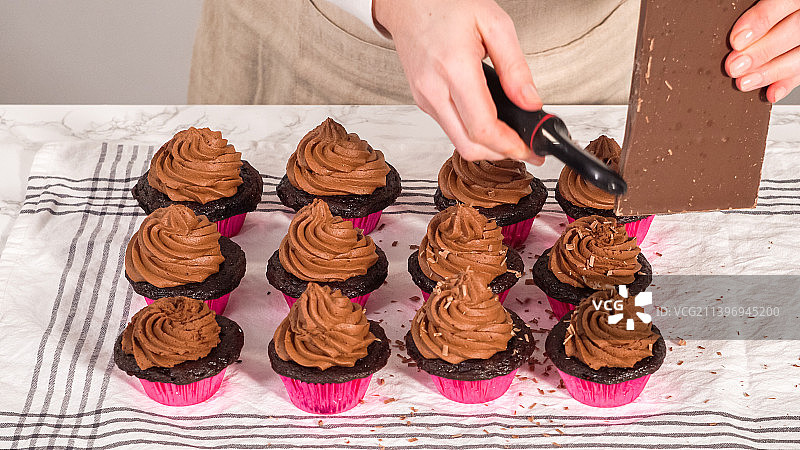 在桌子上给纸杯蛋糕上糖霜的女人身体中部视角图片素材