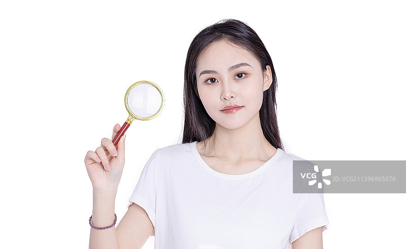 白色背景前的年轻女性手持放大镜图片素材