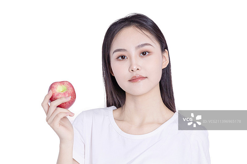 白色背景前吃水果的年轻女性图片素材