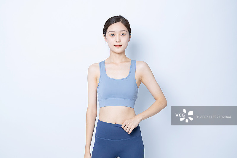 站在白色背景下的运动装年轻女子肖像图片素材