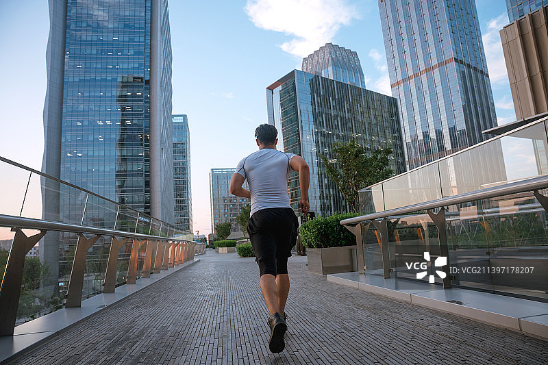 一个年轻人在城市里跑步图片素材