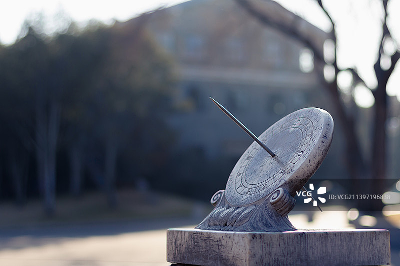 春天里晴朗的天气，蓝天下、阳光里，北京清华大学校园里，传统建筑背景下的日晷雕塑。图片素材