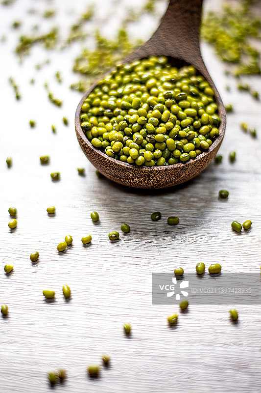 散落桌上的一勺绿豆特写镜头图片素材