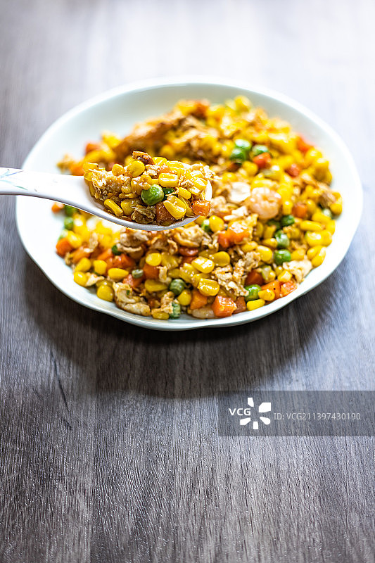 放在餐桌上的一盘三鲜玉米虾仁特色菜图片素材