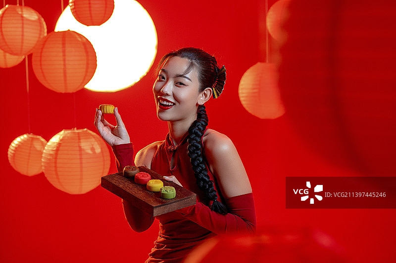 漂亮的年轻国潮女子拿着月饼图片素材