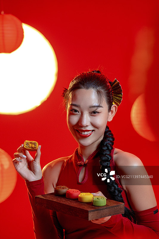 漂亮的年轻国潮女子拿着月饼图片素材