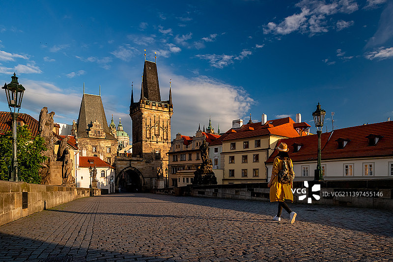 一个中国游客在布拉格查理大桥上行走图片素材