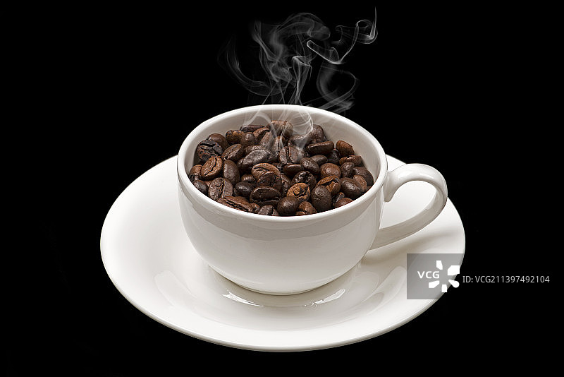 黑色背景下的咖啡杯与咖啡豆特写图片素材