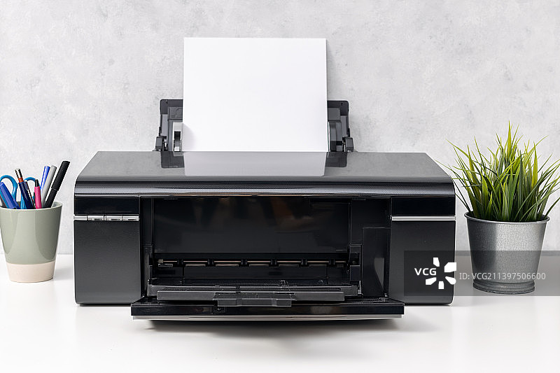 办公桌上带有空白纸张的喷墨打印机图片素材