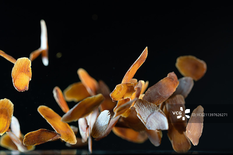 红参片在黑色背景上跳起来高速棚拍广告素材图片素材