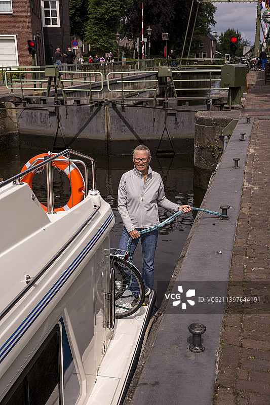 女人在荷兰运河上系着摩托艇图片素材