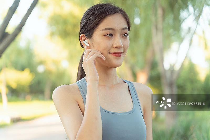 公园里带耳机的年轻女子的特写镜头图片素材