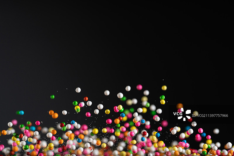 各色糖果颗粒在黑色背景上跳起来高速棚拍广告素材图片素材