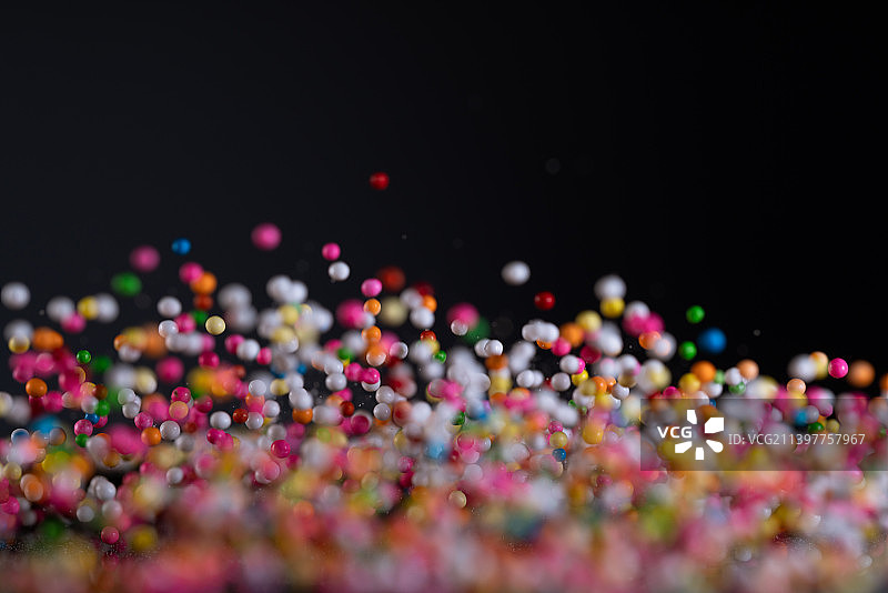各色糖果颗粒在黑色背景上跳起来高速棚拍广告素材图片素材