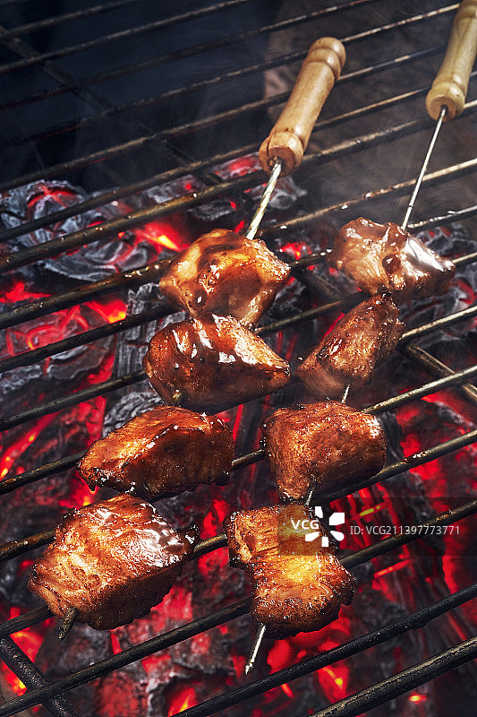 在烤肉架上新鲜烹饪的烧烤肉串图片素材