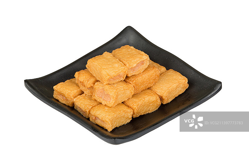 白色背景里有个装满鱼豆腐的黑色方形盘子图片素材