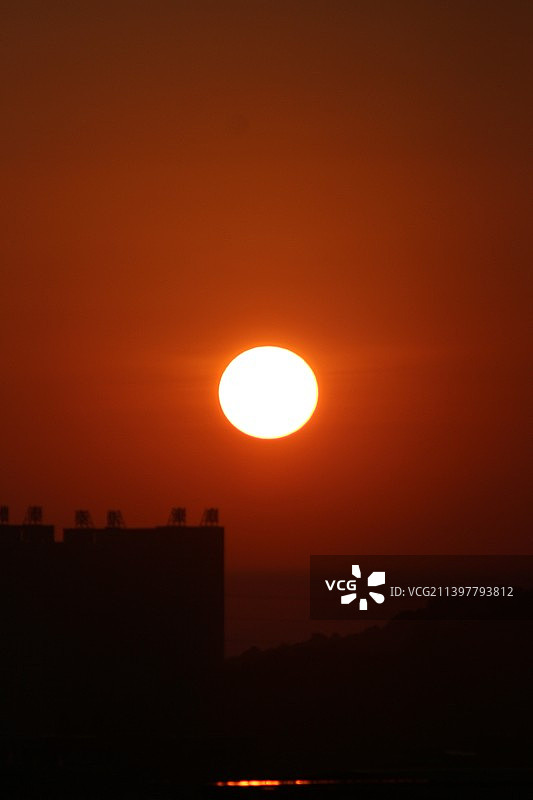 日出时橘红色天空衬托下的剪影景观图片素材