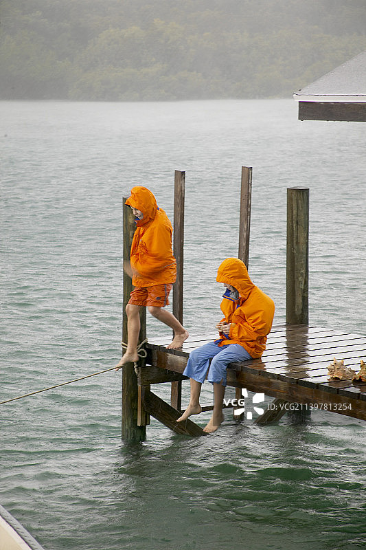 孩子们在雨中码头上玩耍图片素材