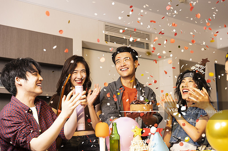年轻朋友们在家里庆祝生日图片素材