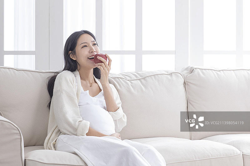 孕妇吃着新鲜水果苹果图片素材