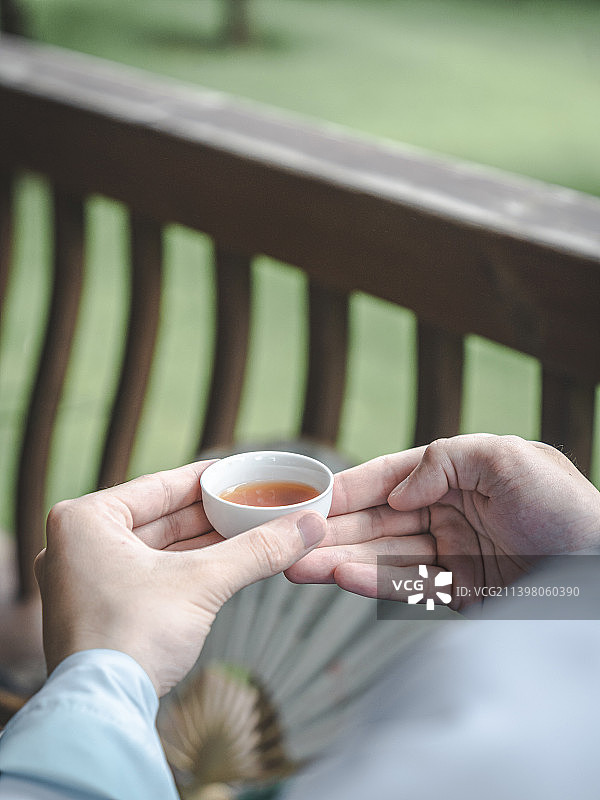 拿着茶杯做敬茶的动作图片素材