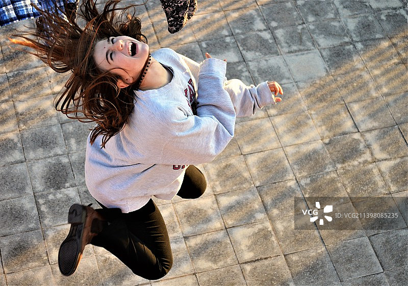 女子在人行道上跳跃的俯视照片图片素材