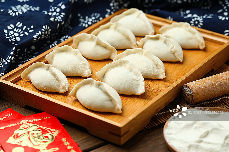 生饺子放在竹盘上图片素材