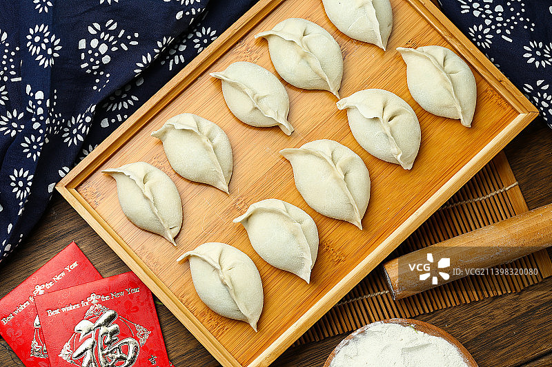 生饺子放在竹盘上图片素材