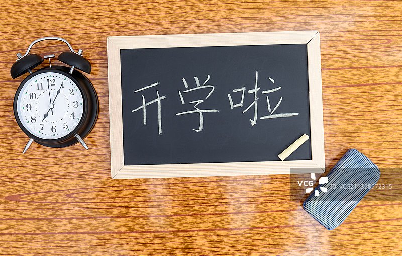 开学季概念课桌上的文具和闹钟图片素材