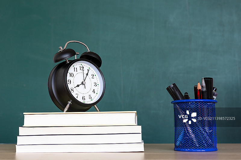 教育概念书桌上的闹钟书籍和文具图片素材