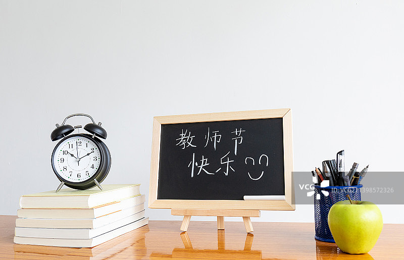 教师节概念书桌上的文具与小黑板图片素材