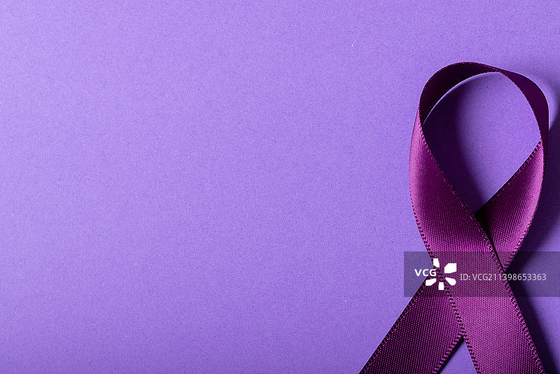 俯视角度拍摄的紫色关爱丝带，紫色背景，留白图片素材