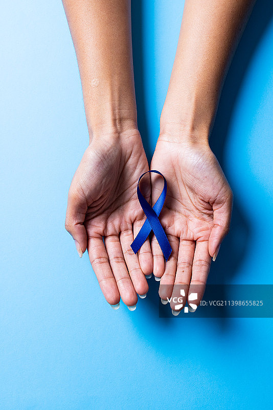 非洲裔中年妇女手持蓝色关爱丝带的特写图片素材
