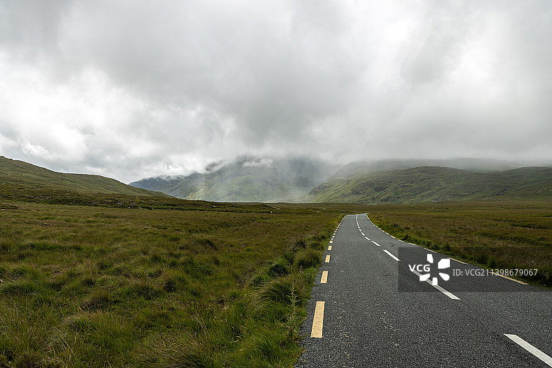爱尔兰梅奥天空背景下的田野上的空旷道路图片素材