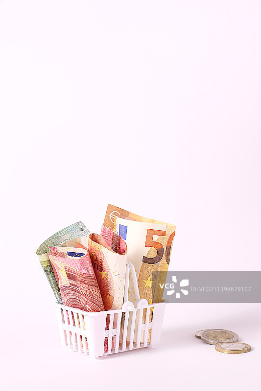 超市购物篮里的欧元和美分，金融购物车图片素材