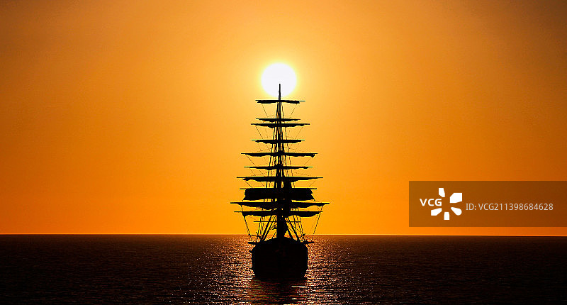 意大利里窝那橙色天空下的帆船剪影图片素材