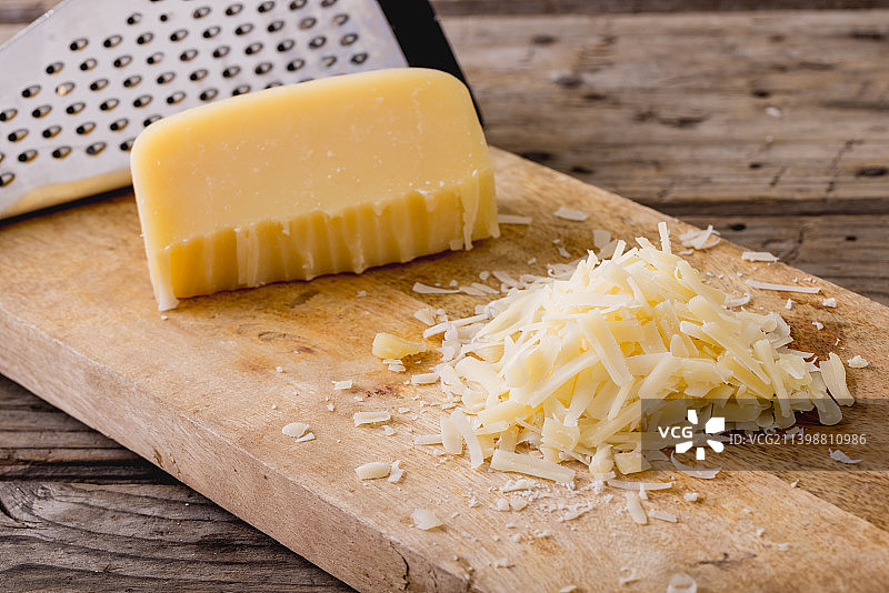 木板上的奶酪丝和磨碎器特写，带文案空间图片素材