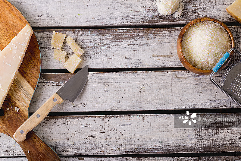 磨碎的奶酪与擦丝器和刀在木桌上的俯视图，留白图片素材