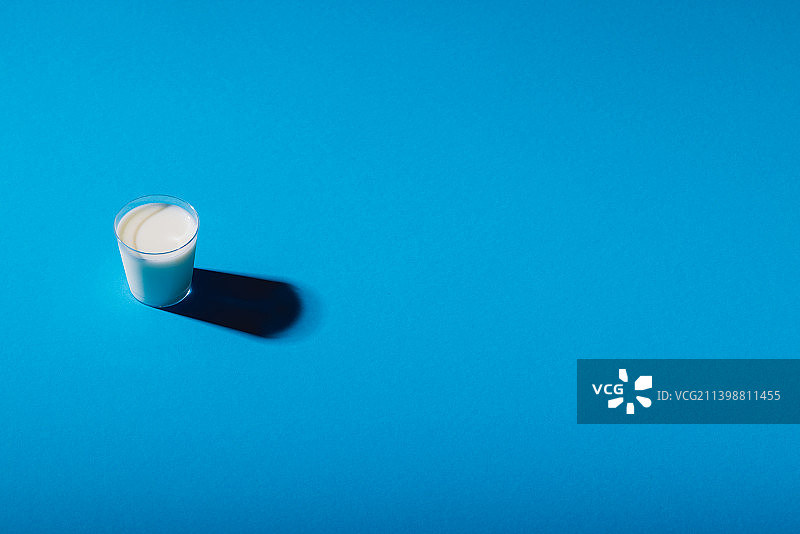 蓝色背景上的牛奶杯俯视图，留有文案空间图片素材