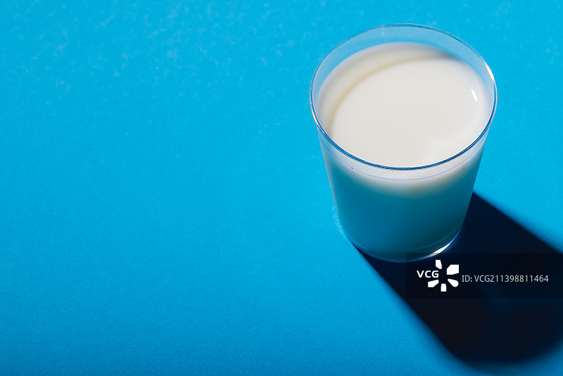 蓝色背景上的牛奶杯（高角度拍摄）图片素材