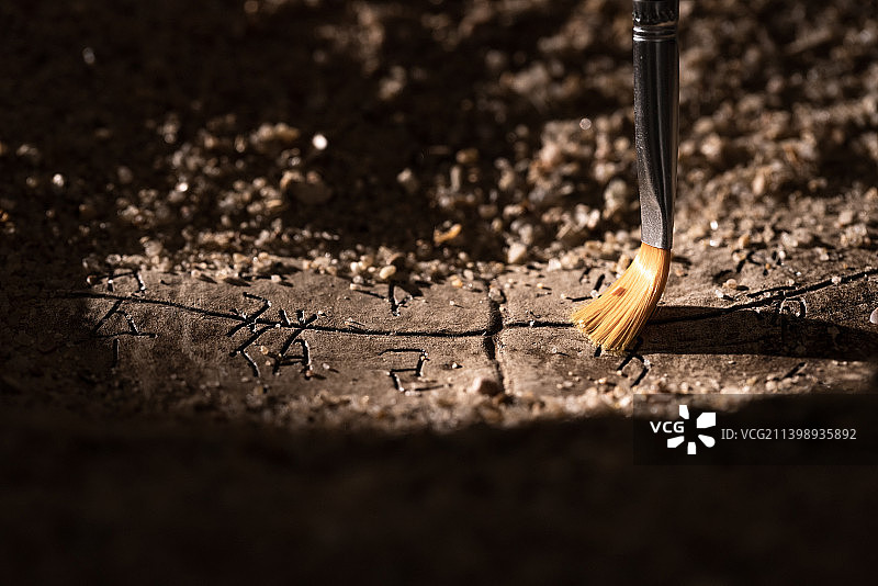 用刷子轻扫文物上的沙土图片素材