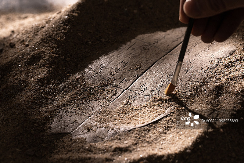 用刷子轻扫文物上的沙土图片素材