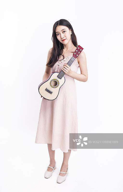 穿着粉色连衣裙拿着尤克里里的女孩图片素材