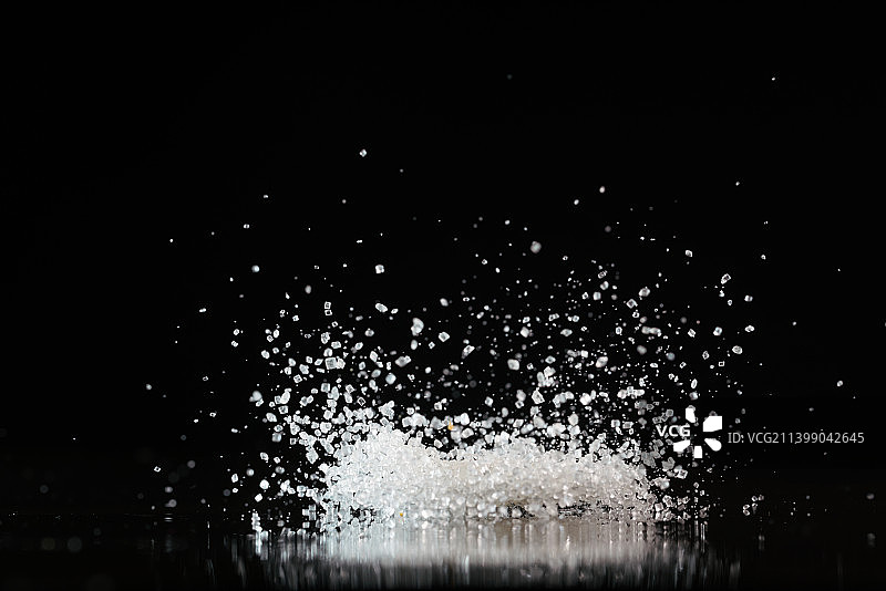 白糖颗粒在黑色背景上跳起来高速棚拍广告素材图片素材
