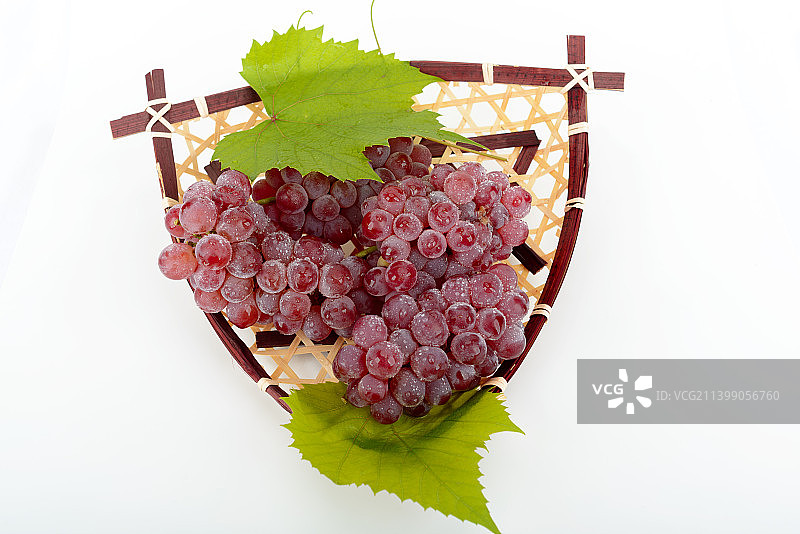 白色背景下竹筐里的葡萄图片素材