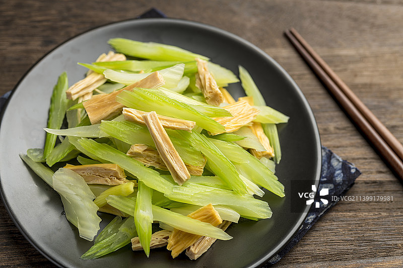 一盘芹菜拌腐竹凉拌菜特写木桌面背景图片素材