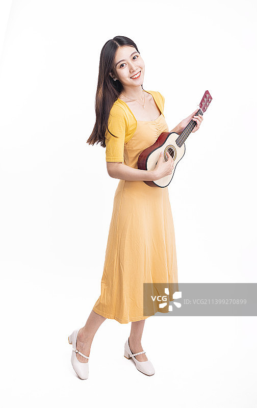 穿着黄色连衣裙拿着尤克里里的女孩图片素材