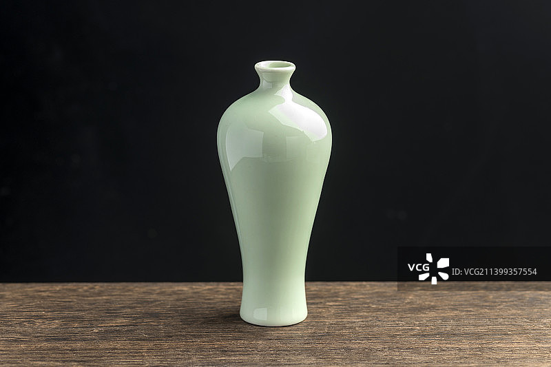 梅瓶绿萝插花摆放在木桌面上特写图片素材