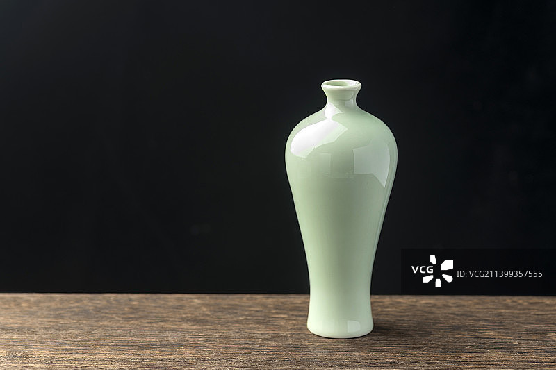 梅瓶绿萝插花摆放在木桌面上特写图片素材